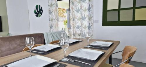un tavolo in legno con bicchieri da vino sopra di Cosy 2BD Home-Only 7 Mins walk to La Preneuse Beach & Shops a Rivière Noire