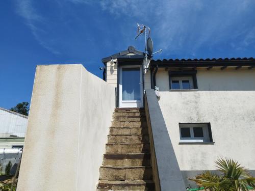 una escalera que conduce a una casa con puerta en Studio au coeur de la ferme, en Saint-Lumine-de-Coutais