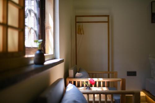 a room with a table and chairs and a window at Elsewhere Hotel Inn Ancient City Center Branch in Pingyao