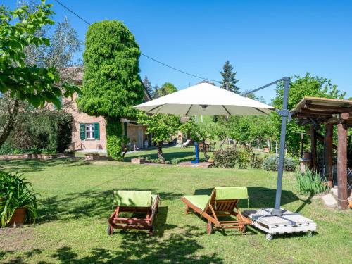 a patio with two chairs and an umbrella at Holiday Home Il Valletto by Interhome in Mombaruzzo