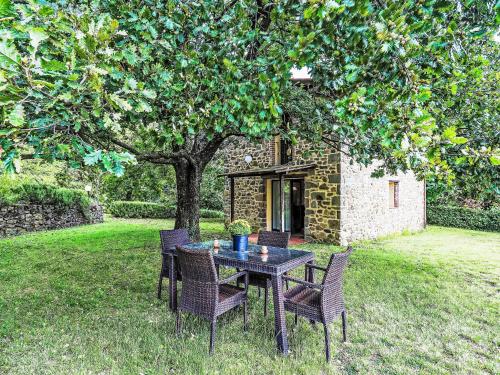 uma mesa e cadeiras debaixo de uma árvore num quintal em Holiday Home La Cupola- Girasole by Interhome em Pescia