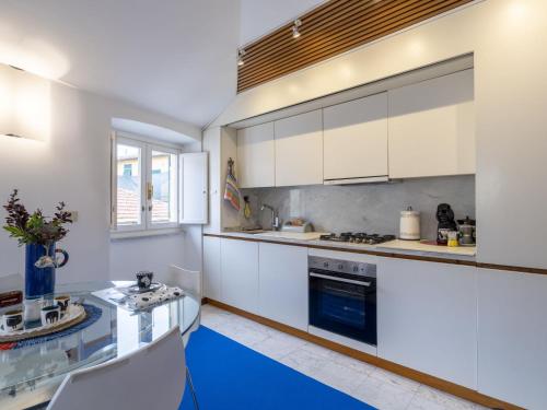 a kitchen with white cabinets and a blue floor at Apartment Torre Antica-1 by Interhome in Noli