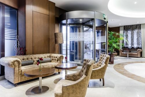 a lobby with a couch and chairs and tables at Hotel Reina Cristina in Teruel