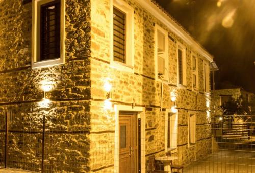 a building with lights on the side of it at night at MARIANTHI'S STONE HOUSE- Studio2 in Metangítsion