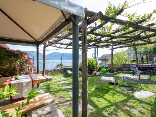 un patio trasero con pérgola y vistas al agua en Holiday Home Meri by Interhome, en Cannero Riviera