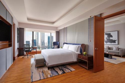 um quarto com uma cama, uma secretária e um sofá em The Ritz-Carlton Jakarta, Mega Kuningan em Jakarta