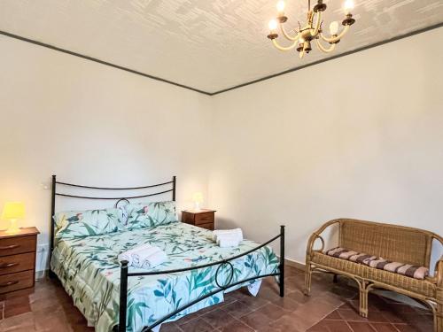 een slaapkamer met een bed, een kroonluchter en een stoel bij Holiday Home La Canonica - PRE190 by Interhome in Praelo