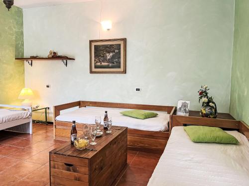 um quarto com duas camas e uma mesa com copos de vinho em Apartment Lupi - DOL220 by Interhome em Costa Carnara