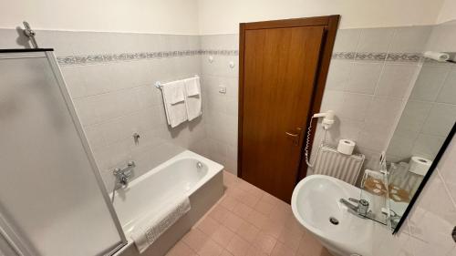 y baño con bañera, aseo y lavamanos. en Albergo Stella Alpina, en Tenno