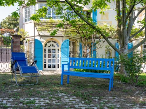 eine blaue Bank und ein Stuhl vor einem Haus in der Unterkunft Holiday Home La Meridiana-1 by Interhome in San Damiano dʼAsti