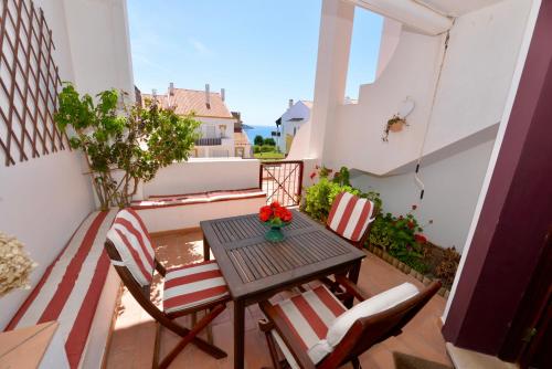 a small balcony with a table and chairs at Paddle - Sea view apartment with 3 pools, tennis & squash court in São Martinho do Porto