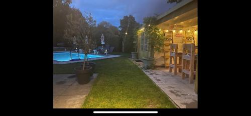 a yard with a swimming pool and a house at B&B Maison Saint Tropez Eindhoven in Eindhoven