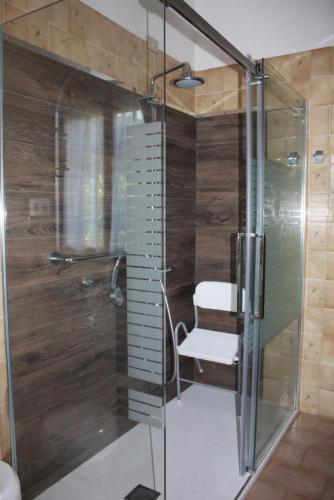 a glass shower in a bathroom with a chair at Villino Maria in Dazio