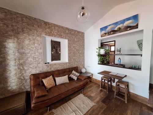 a living room with a brown couch and a table at Cocorelax 2 Otro Lugar de Relax en Lanzarote in Guatiza