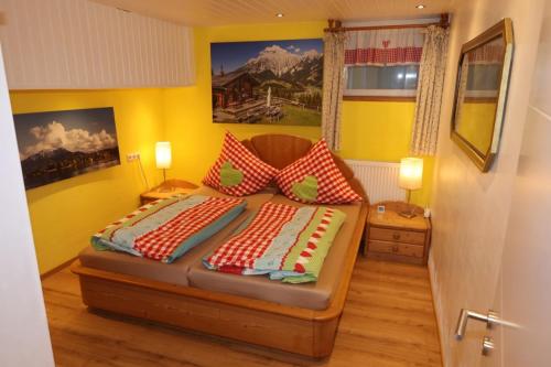 a bedroom with a bed with red and white pillows at Ferienwohnungen Lärchennest zwischen Chiemsee und Bergen in Bernau am Chiemsee