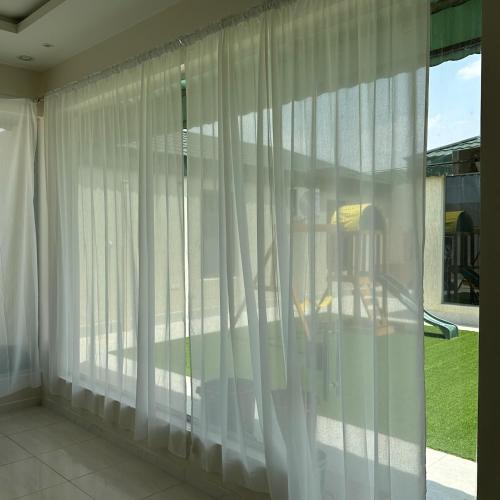 una ventana con cortinas blancas en una habitación en شاليهات حلم, en Al Aqiq