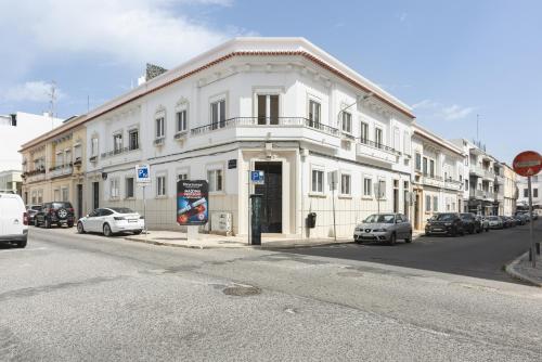 a white building on the side of a street at City Rooms Guest House by HD in Faro