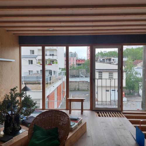 Cette chambre dispose d'une grande fenêtre offrant une vue sur un bâtiment. dans l'établissement maison d'architecte, à Saint-Ouen