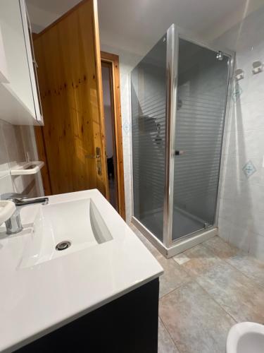 a bathroom with a shower and a white sink at Villa Maccioni in Budoni