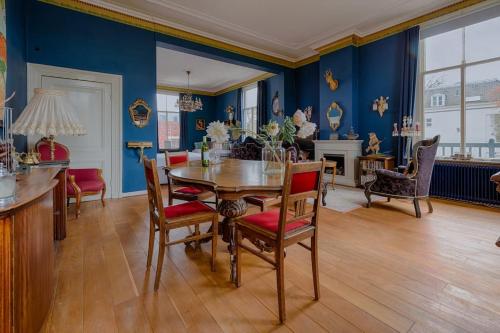 ein Esszimmer mit blauen Wänden sowie einem Tisch und Stühlen in der Unterkunft Villa Dalenstein in Velp