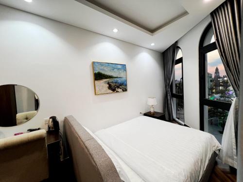 a bedroom with a bed and a mirror at Legacy Hotel - Grand World Phú Quốc in Phu Quoc
