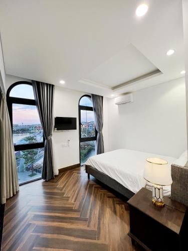 a bedroom with a bed and a large window at Legacy Hotel - Grand World Phú Quốc in Phu Quoc