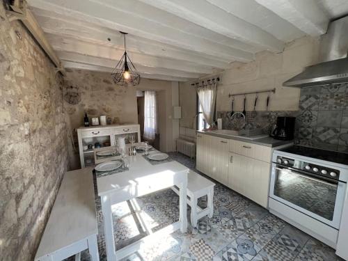 - une cuisine avec une table blanche dans une pièce dans l'établissement La tour du puits 5 min Beauval, à Saint-Aignan