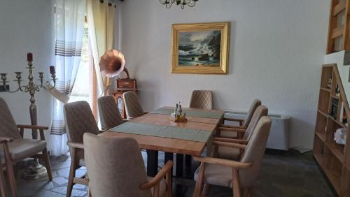 a dining room with a wooden table and chairs at Hotel Margjeka in Valbonë