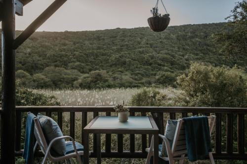 a table and chairs on a porch with a view of a mountain at Thunzi Bush Lodge in Beachview