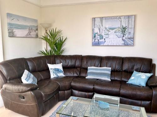 The KinBrae Apartment في توركواي: أريكة جلدية بنية في غرفة المعيشة