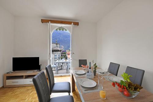 uma sala de jantar com uma mesa e cadeiras e uma televisão em Castle View - Happy Rentals em Bellinzona