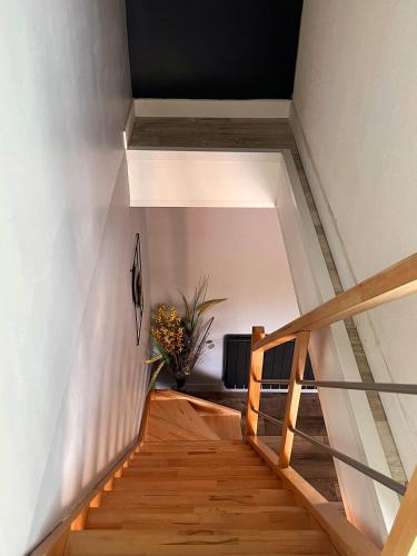 eine Treppe in einem Haus mit einer Blumenvase in der Unterkunft Nature et Moi in Wittes