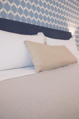 a bed with white sheets and pillows on it at Selinunte Boutique Hotel in Marinella di Selinunte