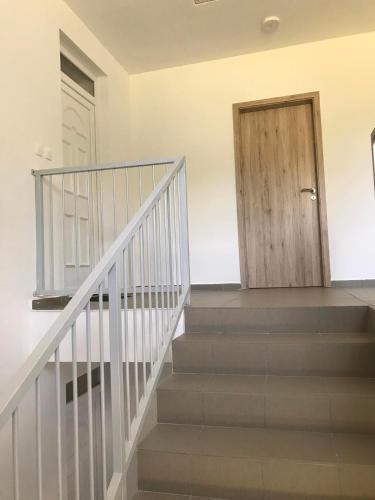 a staircase with a wooden door in a house at Dudy's Flat in Sárvár
