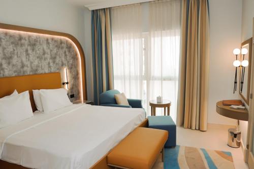 a hotel room with a large bed and a desk at Sheraton Khalidiya Hotel in Abu Dhabi