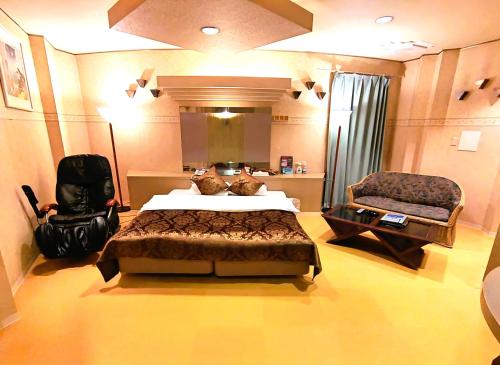 una camera con un grande letto e una sedia di Surfrider Adult Only a Sendai