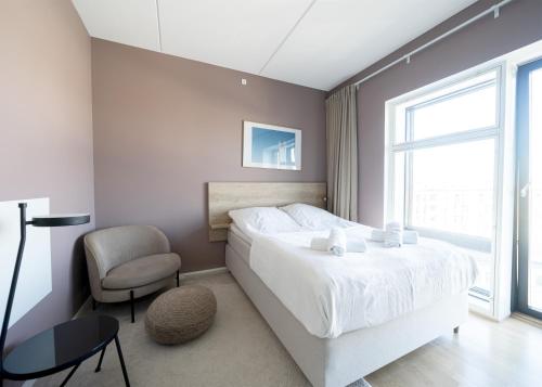 a bedroom with a white bed and a chair at Cool studio in the South Harbour in Copenhagen