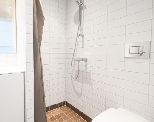 a shower in a white tiled bathroom with a toilet at Cool studio in the South Harbour in Copenhagen