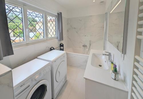 - une buanderie blanche avec un lave-linge et un évier dans l'établissement Ref JAS - Palmes dProperties, à Cannes