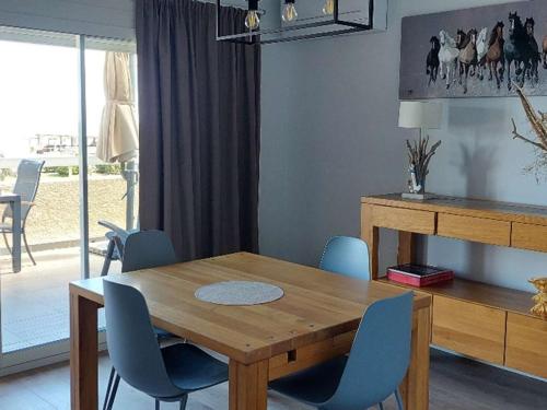 une salle à manger avec une table en bois et des chaises bleues dans l'établissement T3 climatisé avec wifi, terrasse, parking - Argelès-sur-Mer - FR-1-388-82, à Argelès-sur-Mer