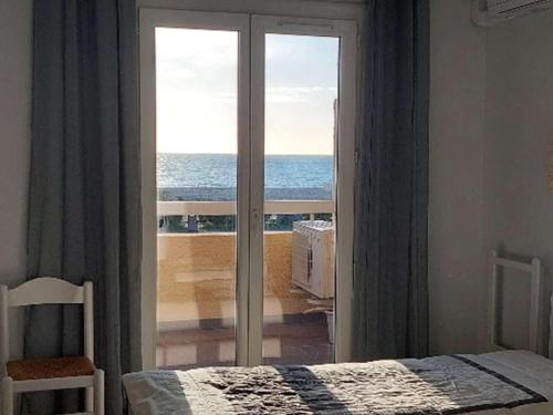 - une chambre avec une porte coulissante en verre offrant une vue sur l'océan dans l'établissement T3 climatisé avec wifi, terrasse, parking - Argelès-sur-Mer - FR-1-388-82, à Argelès-sur-Mer