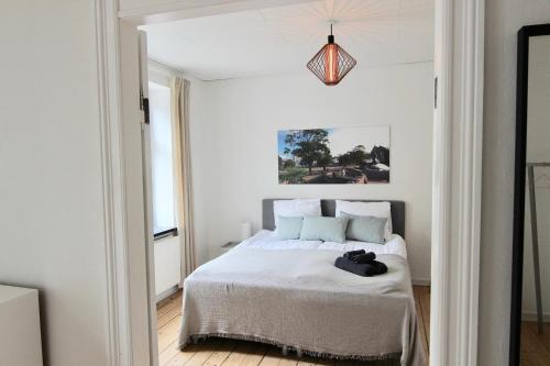 een slaapkamer met een bed en een hanglamp bij Lovely 2-BR in one of Århus best locations - 56 in Aarhus