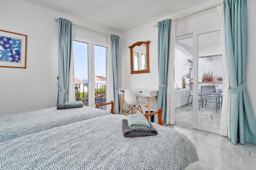 a bedroom with two beds and a desk in it at Apartamento Vistamar Marina in Almuñécar