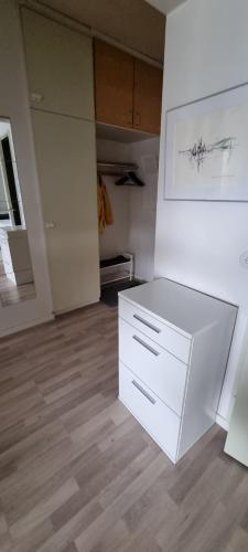 um quarto vazio com um armário branco e uma cozinha em Linnankatu Apartment em Savonlinna