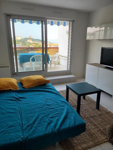 - une chambre avec un grand lit bleu et une table dans l'établissement Biarritz Milady, à Biarritz