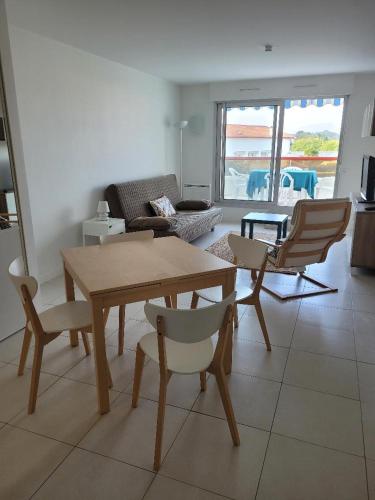 un salon avec une table et des chaises en bois dans l'établissement Biarritz Milady, à Biarritz