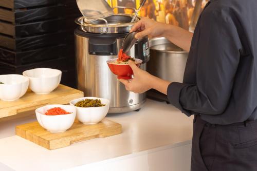 a person is preparing food in a kitchen at ANA Crowne Plaza Fukuoka by IHG in Fukuoka