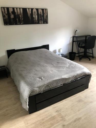 - un lit dans une chambre avec un cadre de lit dans l'établissement Chambres chez Philippe, à Ludres