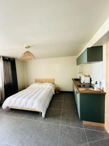une chambre avec un grand lit et une cuisine dans l'établissement Studio Mimosa - 500m de la plage, à Lacanau
