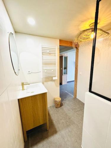 une salle de bain avec un lavabo et un miroir dans l'établissement Studio Mimosa - 500m de la plage, à Lacanau